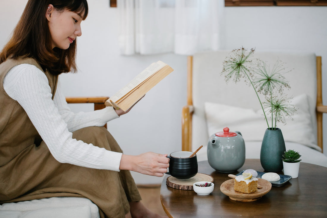 Woman reading a book and enjoying tea