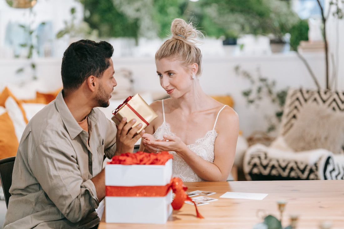 Couple exchanging a romantic gift at a cozy table, surrounded by love-themed decor, symbolizing connection and intimacy enhanced by herbal aphrodisiacs.