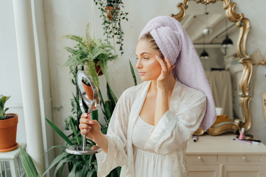 Woman in white bathrobe with towel over her hair