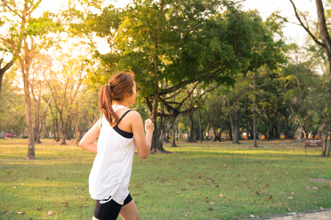 Woman jogging outdoors in a park during sunrise, symbolizing energy and endurance boosted by herbs like ginseng, cordyceps, and Yerba Mate