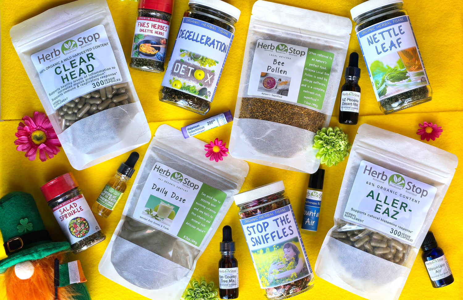 Spring wellness products from Herb Stop, featuring greens, detox blends, and natural allergy support, including capsules, teas, bee pollen, essential oils, and seasonings on a bright yellow background with spring flowers and a festive touch