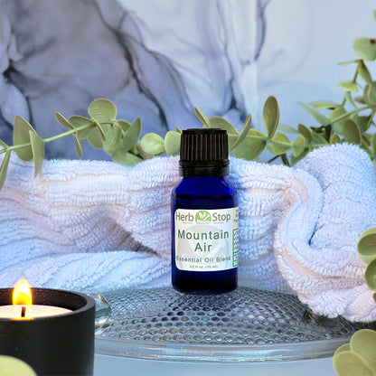 Mountain Air Essential Oil surrounded by eucalyptus and a towel